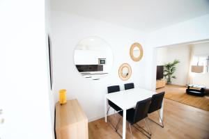 a dining room with a white table and chairs at LUZ DE PATIOS in Huelva