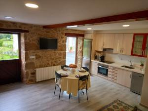 a kitchen with a table and chairs in a room at Casa Xan in Jove