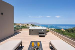 a hot tub on the balcony of a house at Villa Ekphrasis with sea view and jacuzzi in Ravdhoúkha