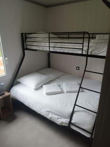 - une chambre avec des lits superposés dotés de draps et d'oreillers blancs dans l'établissement Erreka pays basque, à Hasparren