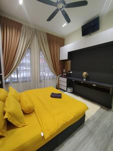Homestay 4BR with Outdoor Pool في باسير غونداغ: سرير أصفر كبير في غرفة النوم مع مروحة سقف