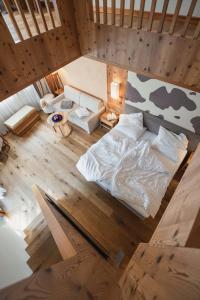 einen Blick über ein Schlafzimmer mit einem Bett und einem Sofa in der Unterkunft Hotel Emmy - five elements in Völs am Schlern