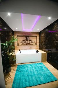 een badkamer met een bad en een blauw tapijt bij LUZ DE PATIOS in Huelva