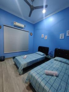 two beds in a room with a large screen at Homestay 4BR with Outdoor Pool in Pasir Gudang