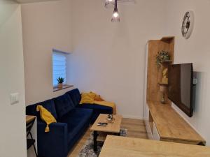 a living room with a blue couch and a table at Apartman Gallery in Slavonski Brod