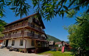 - un bâtiment avec des balcons en bois sur le côté dans l'établissement Pensiunea Malina, à Moieciu de Sus