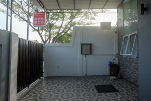 un garage avec une porte blanche et une clôture dans l'établissement RedDoorz near Kawasan Bandara Ahmad Yani Semarang 2, à Kalibanteng-kidul