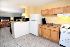 La cuisine est équipée d'un réfrigérateur blanc et d'un évier. dans l'établissement Blue Marlin Motel, à Virginia Beach
