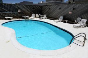 a large swimming pool with chairs and a table at Blue Marlin Motel in Virginia Beach +13 photos