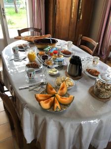 un tavolo con una tovaglia bianca con sopra del cibo di Le clos fleuri - Chambres d'hôtes a Onzain