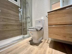 a bathroom with a toilet and a glass shower at Excelente piso en barrio Salamanca! in Madrid