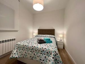 マドリードにあるExcelente piso en barrio Salamanca!の白いベッドルーム(青い掛け布団付きのベッド1台付)