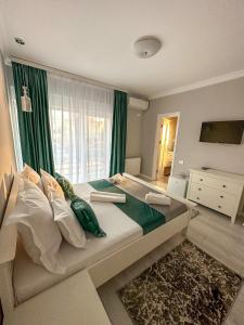 a bedroom with a large bed with green curtains at House Lake in Techirghiol