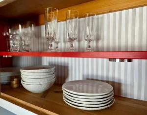 un estante con platos y copas de vino. en bei Servays, en Eppingen