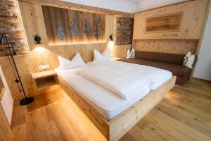 sypialnia z dużym białym łóżkiem w pokoju w obiekcie Aktivhotel Waldhof w mieście Oetz