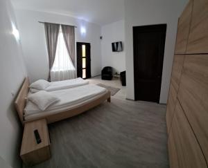 Un dormitorio con una cama grande y una ventana en Casa Dobric, en Sovata