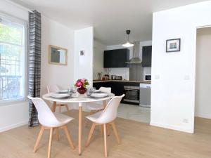 a kitchen and dining room with a white table and chairs at Casaminnie - Appartement à 8 min de Disneyland Paris in Bussy-Saint-Georges