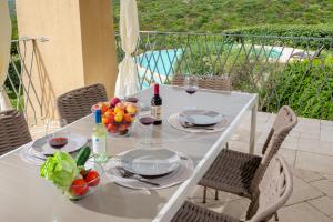 a white table with plates of fruit and wine glasses at Appartamento Eleganza - SHERDENIA Luxury Apartments in Marinella