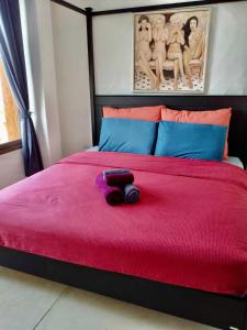 Una cama con colcha roja y un animal de peluche. en Las Tortugas, Cozy condominium on Khao Tao beach, Hua Hin, en Khao Tao