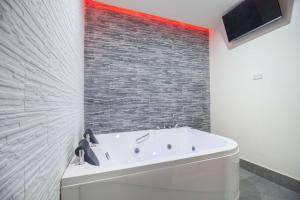 a bath tub in a bathroom with a brick wall at Royal Playa Suite and Apartament -private parking- self chek out in Catania