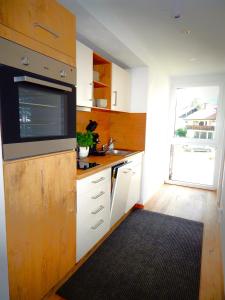 a kitchen with white cabinets and a sink and a window at Vital Lodge Allgäu mit Oberstaufen PLUS in Oberstaufen