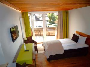 um quarto com uma cama e uma grande janela em Vital Lodge Allgäu mit Oberstaufen PLUS em Oberstaufen