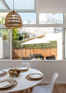 Lisbon Zoo House III في لشبونة: غرفة طعام مع طاولة بيضاء وكراسي