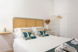 a bedroom with a white bed with two pillows at Lisbon Zoo House III in Lisbon