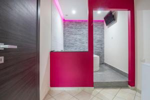 a bathroom with a red door and a toilet at Royal Playa Suite and Apartament -private parking- self chek out in Catania
