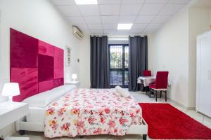 a bedroom with a red and white bed and a red rug at Royal Playa Suite and Apartament -private parking- self chek out in Catania