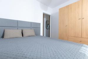 een slaapkamer met een groot bed en een houten kast bij Apartament Perłowy by Major Domus Club in Dziwnów