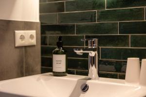 a bottle of wine sitting on top of a sink at Hotel Baumann in Otterfing