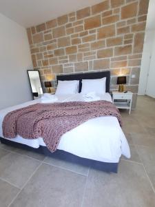 um quarto com uma cama grande e uma parede de tijolos em Villa Mare Blue em Žminj
