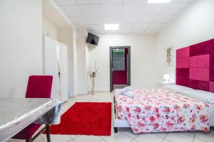 a bedroom with a bed and a red rug at Royal Playa Suite and Apartament -private parking- self chek out in Catania