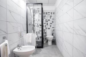a white bathroom with a toilet and a sink at Royal Playa Suite and Apartament -private parking- self chek out in Catania