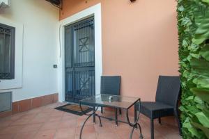 a glass table and chairs in front of a door at Royal Playa Suite and Apartament -private parking- self chek out in Catania