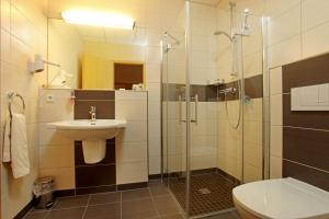 a bathroom with a glass shower and a sink at Sporthotel Neuruppin in Neuruppin