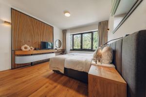 a bedroom with a bed and a large window at Vista Resort & Club in Prague