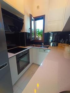 una cucina con armadi bianchi e piano cottura di Inna Suite luxury apartment in the center a Città di Skiathos