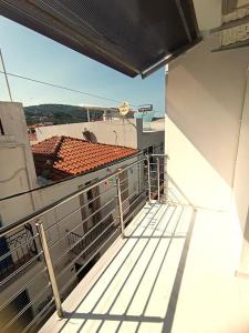 einen Balkon eines Gebäudes mit Blick auf ein Dach in der Unterkunft Inna Suite luxury apartment in the center in Skiathos-Stadt