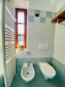 a bathroom with a white toilet and a sink at Mulino del Casale - nature b&b in San Paolo Solbrito