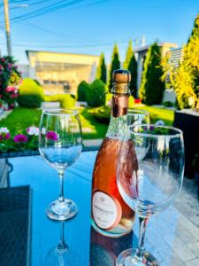 a bottle of wine and two wine glasses on a table at House Lake in Techirghiol