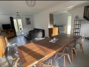a living room with a wooden table and a couch at Gîte Le Rhodo in Thil-Manneville +9 photos