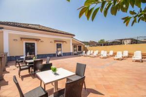 a patio with tables and chairs and a fence at Royal Playa Suite and Apartament -private parking- self chek out in Catania