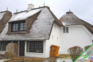 a white house with a thatched roof at Landhaus Meer in Kampen