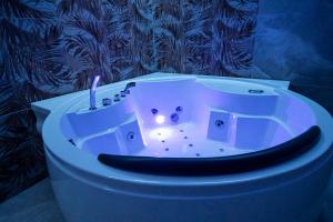 a white bath tub in a bathroom with a sink at Royal Playa Suite and Apartament -private parking- self chek out in Catania