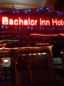 a sign on the side of a building with christmas lights at Bachelor Inn Hotel in Belize City