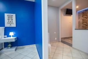 a bathroom with a blue wall and a sink at Royal Playa Suite and Apartament -private parking- self chek out in Catania