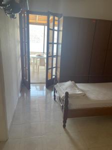 a bedroom with a bed and a door to a table at LITHOS Porto Kagio in Porto Kagio