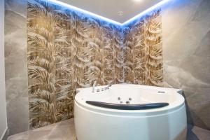 baño con lavabo blanco y papel pintado de oro en Royal Playa Suite and Apartament -private parking-, en Catania